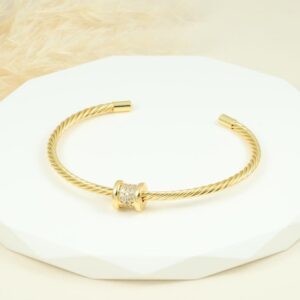 Brazalete dorado con diseño trenzado